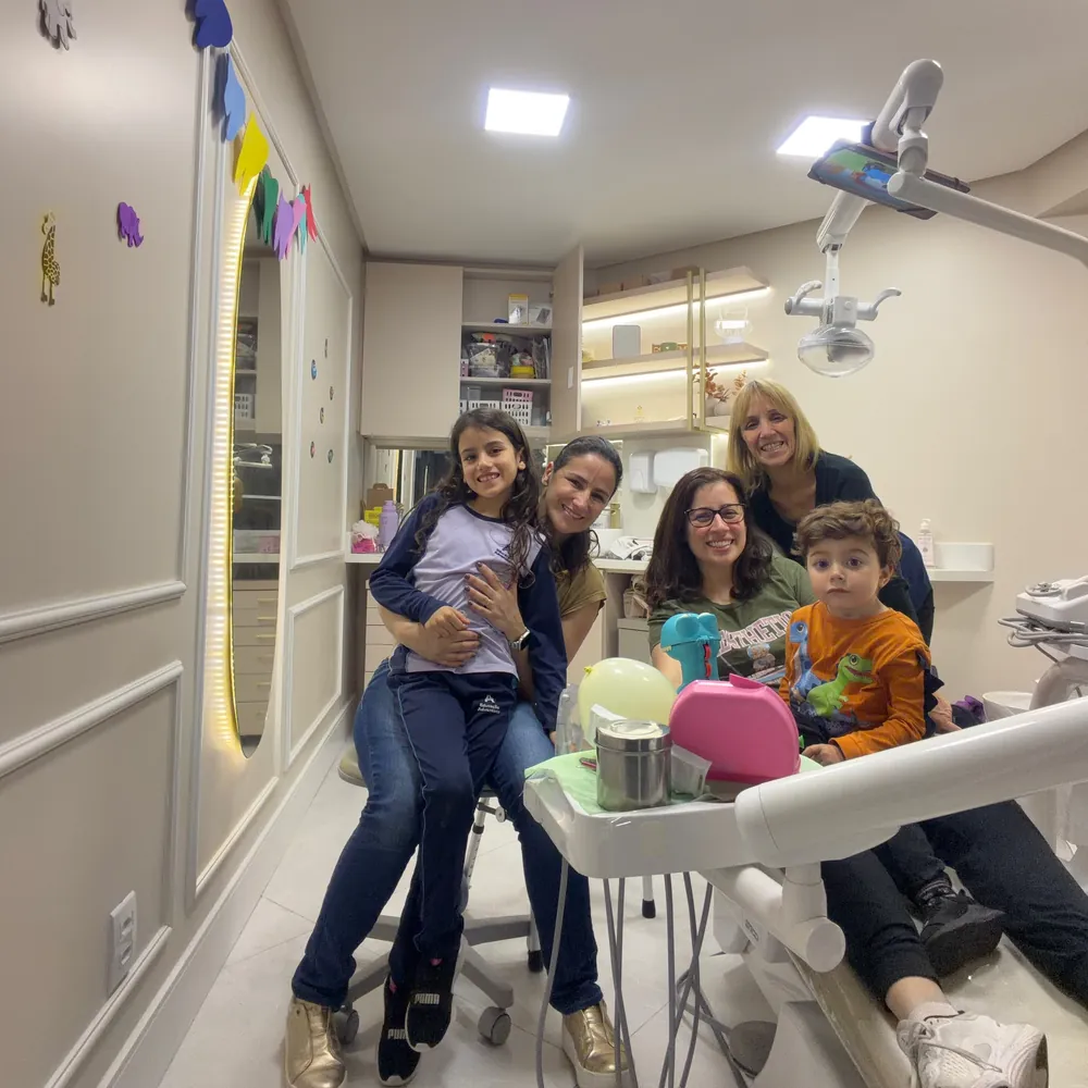 Famílias com crianças sorrindo no consultório infantil decorado
