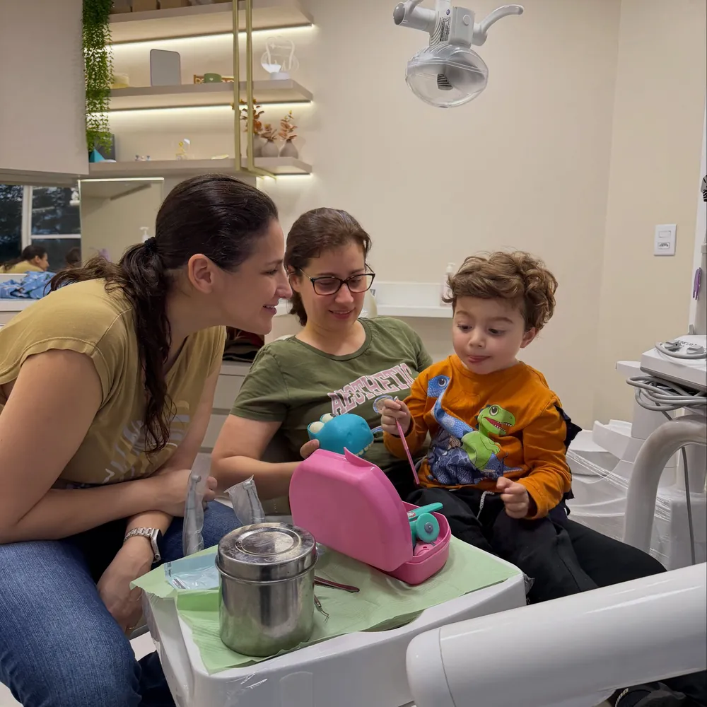 Criança brincando com escova e brinquedos durante a consulta
